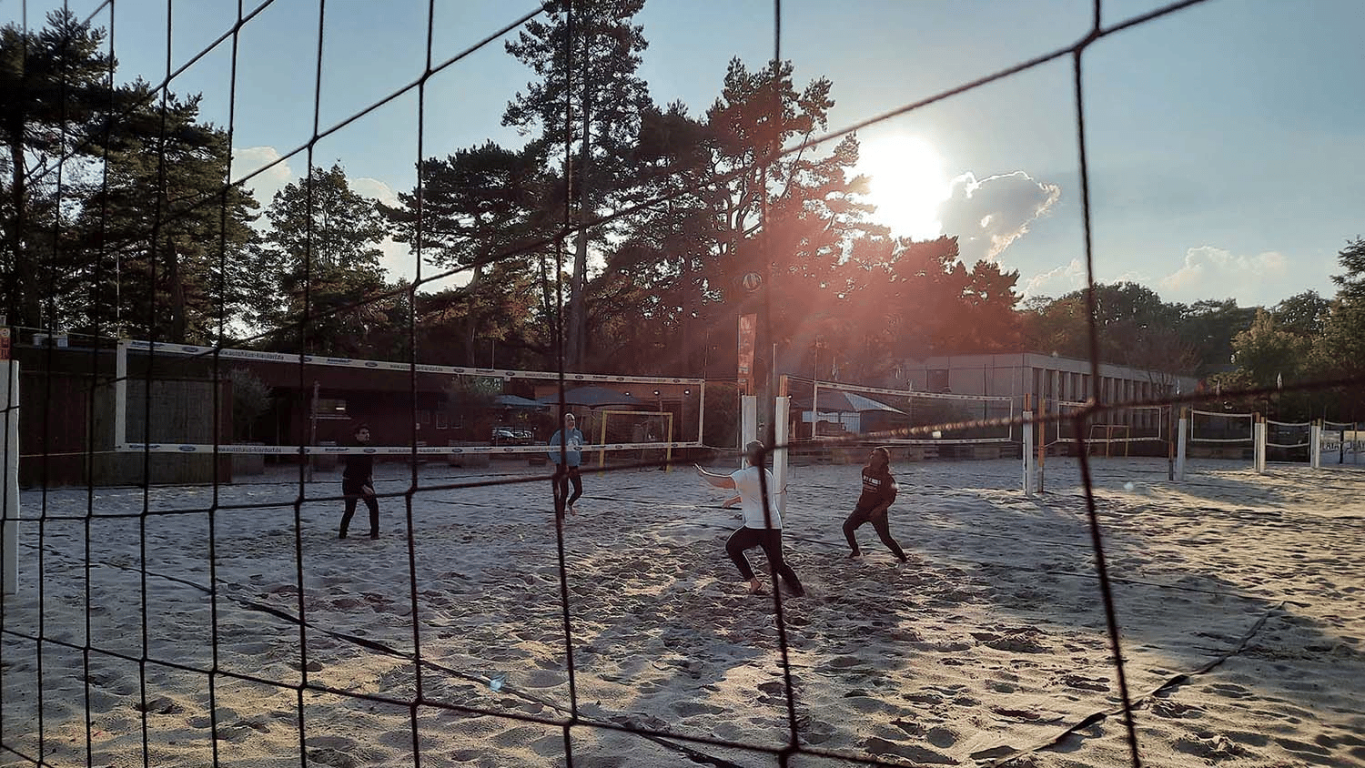 Students and staff play beach volleyball